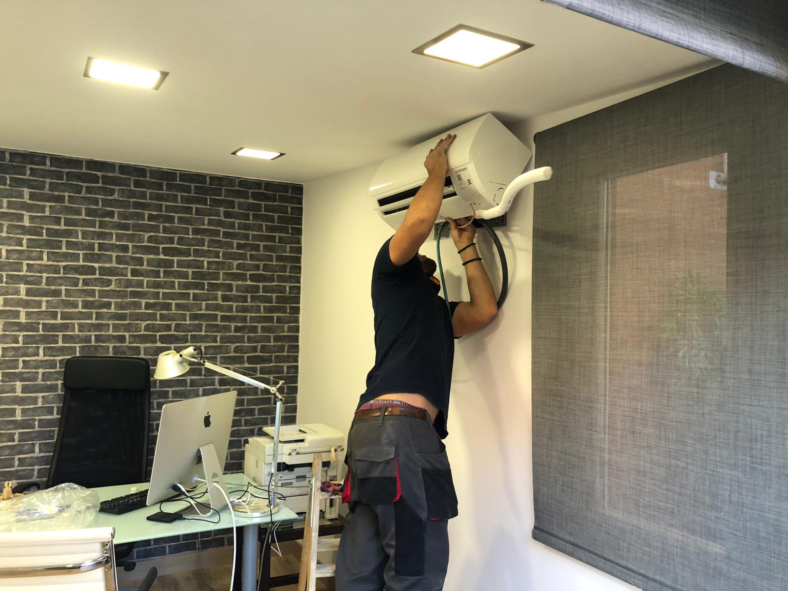 Trabajador instalando aire acondicionado caseta de madera